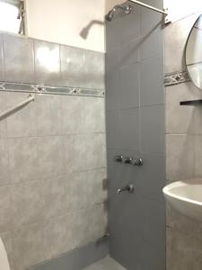uma casa de banho com um chuveiro e um lavatório. em Posada El Cerrito em São Rafael