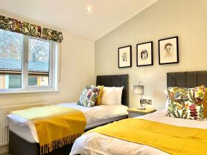 1 dormitorio con 2 camas y ventana en Thirlmere 4 Luxury Lodge at White Cross Bay Windermere, en Windermere