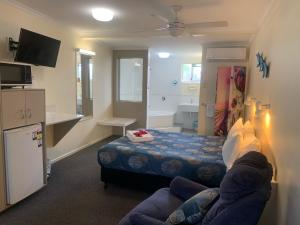 a small room with a bed and a bathroom at Shady Rest Motel in Gympie