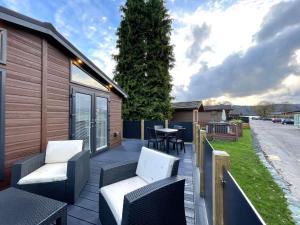 a deck with chairs and a table on a house at Thirlmere 4 Luxury Lodge at White Cross Bay Windermere in Windermere