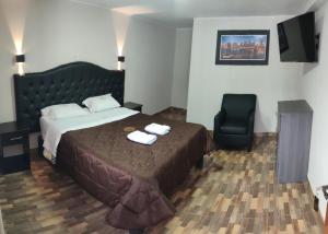 um quarto de hotel com uma cama e uma cadeira em RONALD HOTEL em Churín