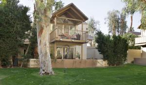 a house with a balcony and a tree at Mountain Cove Private Condo in Indian Wells