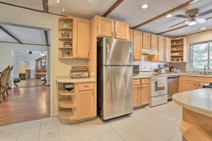 a kitchen with wooden cabinets and a stainless steel refrigerator at Large Greeley House with 2 Game Rooms and Yard! in Lackawaxen