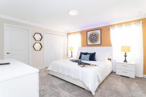 a white bedroom with a white bed and a window at Gorgeous 4 Bd w/ Pool at Champions Gate Resort 1020 in Orlando