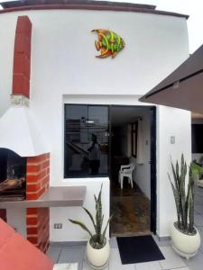 una casa con dos macetas y un lagarto en la pared en Lindo departamento en Punta Hermosa, en Punta Hermosa