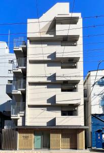 um edifício branco com varandas ao lado em KLASSO Tokyo Sumiyoshi Apartments em Tóquio