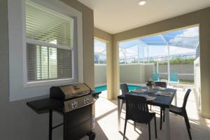 a dining room with a table and chairs and a pool at Gorgeous 4 Bd w/ Pool at Champions Gate Resort 1020 in Orlando