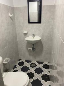 een badkamer met een wit toilet en een wastafel bij ALOJAMIENTO CON PARQUEO CERCA A LA BASÍLICA in Buga