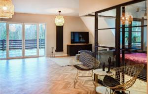 a living room with chairs and a bed and a television at 2 Bedroom Cozy Apartment In Stezyca in Stężyca