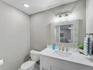 un bagno bianco con lavandino e specchio di Galveston Escapes - Walk to Beach and Restaurants a Galveston Altre 23 foto