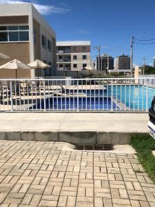 een zwembad met parasols voor een gebouw bij Apartamento Vog Atlântico in Ilhéus