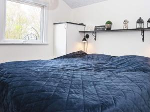 um quarto com uma cama azul e uma janela em Holiday home Sydals LXXVII em Sønderby