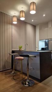 a kitchen with two bar stools and a counter at New Modern Apartment near Heathrow Airport in Yiewsley