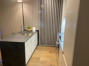 a kitchen with a sink and a counter top at New Modern Apartment near Heathrow Airport in Yiewsley