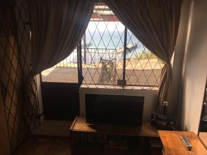 sala de estar con ventana grande y TV en Casa Hostal Vista al Mar, en Valparaíso