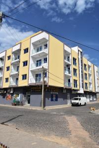 een geel gebouw met een witte auto ervoor geparkeerd bij Taninho in Santa Maria