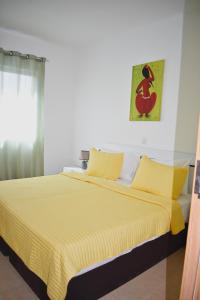 een slaapkamer met een geel bed en een gele deken bij Taninho in Santa Maria