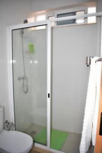 a bathroom with a glass shower with a toilet at Taninho in Santa Maria