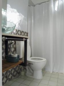 y baño con aseo blanco y lavamanos. en Departamento El Nogal en Villa Santa Cruz del Lago