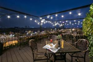 a patio with tables and chairs and lights at 22Land Residence Hotel & Spa Ha Noi in Hanoi