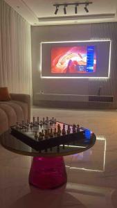Neuf et raffiné, centre ville Rabat في الرباط: غرفة معيشة مع طاولة شطرنج أمام التلفزيون