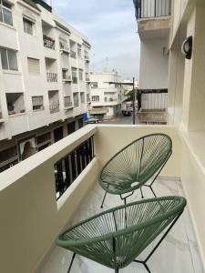 zielone krzesło siedzące na balkonie budynku w obiekcie Neuf et raffiné, centre ville Rabat w mieście Rabat