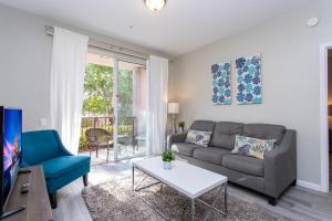 un soggiorno con divano e tavolo di Magnificent 2 Bedroom Apartment Vista Cay Resort 107 a Orlando