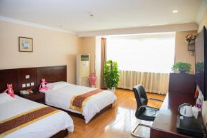 a hotel room with two beds and a desk and a television at Meiyuan Hotel in Beijing