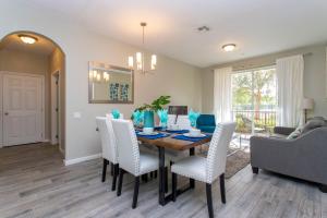 comedor y sala de estar con mesa y sillas en Magnificent 2 Bedroom Apartment Vista Cay Resort 107, en Orlando