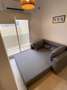 una pequeña sala de estar con sofá y ventana en EXCELENTE DEPTO A MTS DE Bv GALVEZ C en Santa Fe