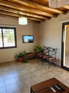 ein Wohnzimmer mit einem TV und einem Tisch in der Unterkunft CASA TUNUYÁN in Tunuyán