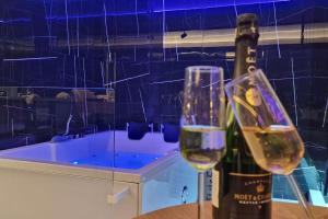 a bottle of wine and two glasses on a table at Romantic & Jacuzzi in Skopje