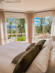 1 cama con almohadas frente a una ventana en Ballandean Views, Ballandean Queensland, en Ballandean