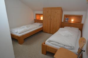 トゥクスにあるHaus Irmgard by Châtel Reizenのベッド2台 木製キャビネット付きの部屋