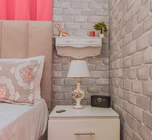 a bedroom with a bed and a nightstand with a lamp at A-1 Hermoso Apartamento tipo villa al pie de la montaña elitevillasjarabacoa in Jarabacoa