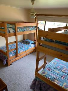 a bedroom with two bunk beds in a room at Bott's Beach Retreat - Maslin Beach - 100M to beach in Maslin Beach