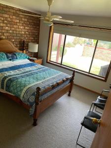 a bedroom with a bed and a large window at Bott's Beach Retreat - Maslin Beach - 100M to beach in Maslin Beach