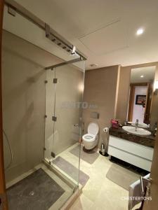uma casa de banho com um chuveiro, um WC e um lavatório. em FES Penthouse Champs de course em Fez