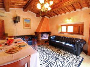 a living room with a black leather couch and a table at Belvilla by OYO Villa Valardegna in Montepulciano
