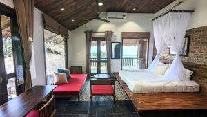 1 dormitorio con 1 cama grande y un banco rojo en Amigo Pu Luong, en Làng Bang