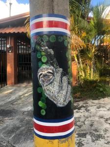 un poste con un cocodrilo pintado a su lado en Casa Lupita Alajuela, en Alajuela