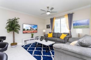 a living room with a couch and a table at Gorgeous 4Bd Close to Disney w/ Pool @ Champions Gate Resort 1196 in Davenport