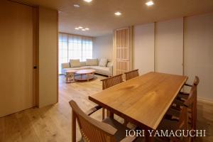 a dining room with a table and a couch at IORI Stay HIDA in Hida