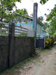 a blue house with a fence in front of it at TeSario Retreat in General Luna