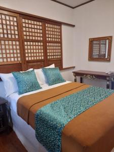 a bedroom with a large bed with blue pillows at BALÉ in Malabañas