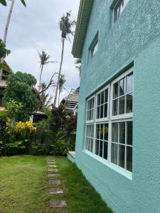 a blue house with a yard next to it at TeSario Retreat in General Luna