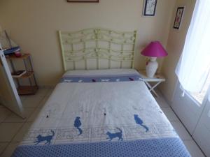 Un dormitorio con una cama con una colcha azul con gatos. en Maison Jullouville, 4 pièces, 6 personnes - FR-1-361-149, en Jullouville-les-Pins