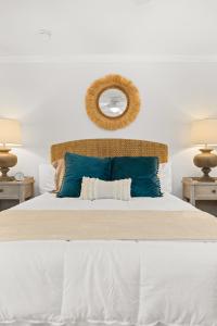 a bedroom with a large bed with blue pillows at Palmetto House of Charleston in Charleston