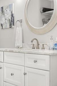 ein weißes Badezimmer mit einem Waschbecken und einem Spiegel in der Unterkunft Palmetto House of Charleston in Charleston