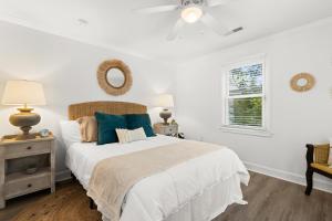 ein weißes Schlafzimmer mit einem Bett und einem Fenster in der Unterkunft Palmetto House of Charleston in Charleston